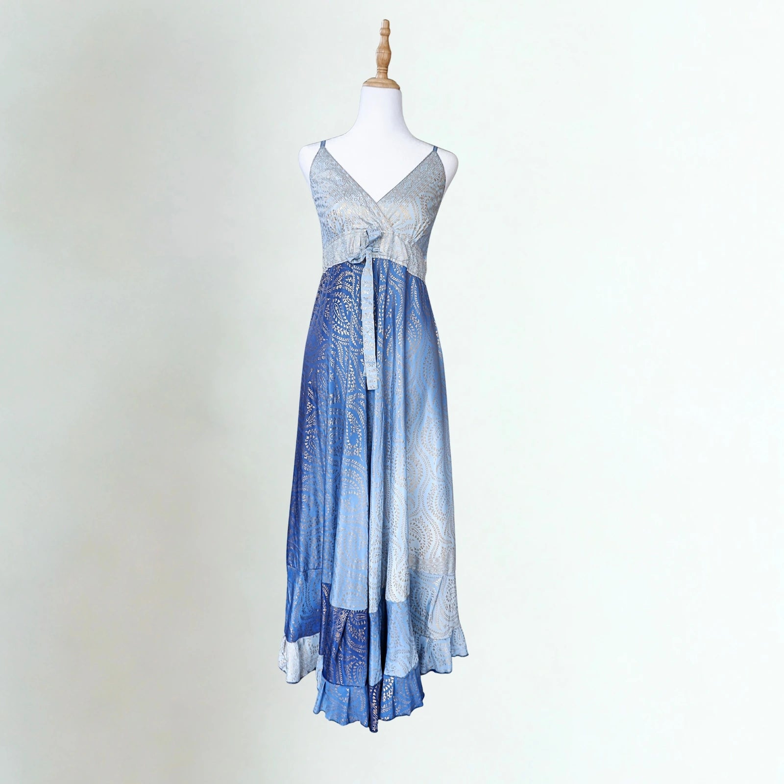 Blue and white dress on a mannequin against a plain background