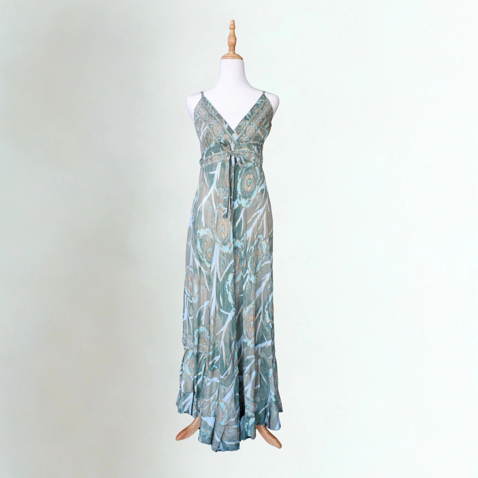 Long patterned dress on a mannequin against a plain background