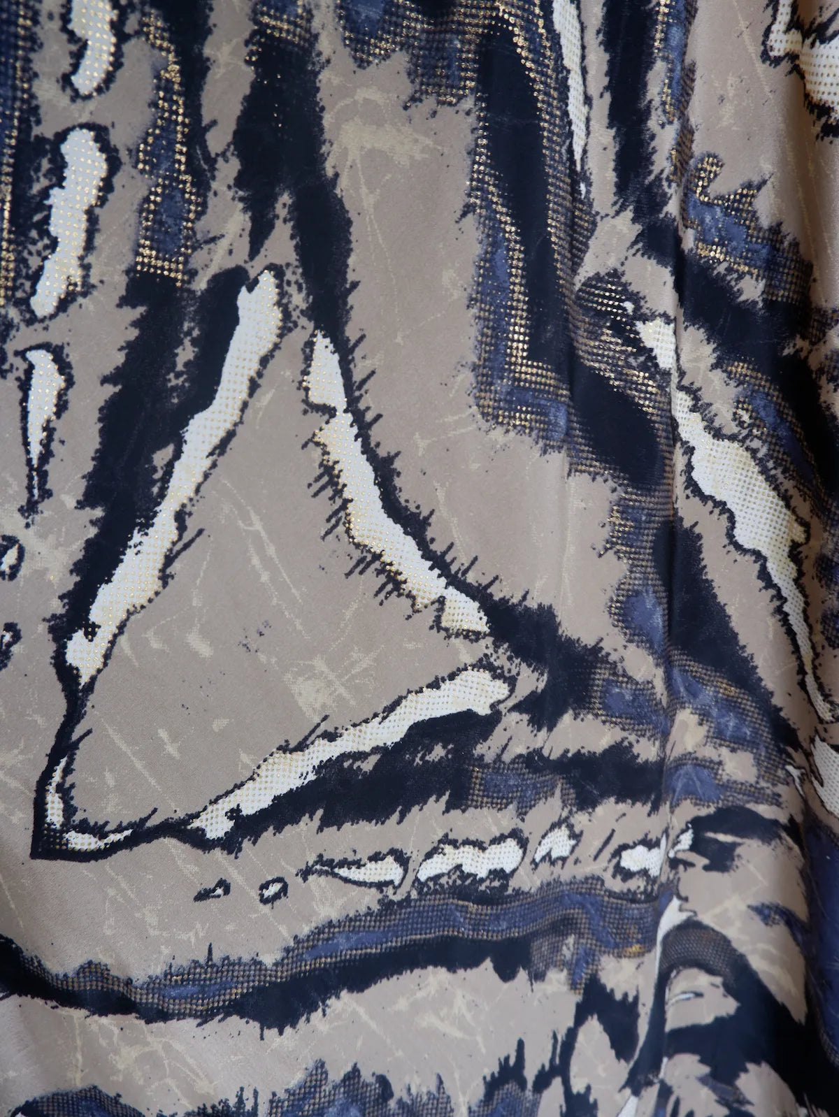 Close-up of a patterned fabric with blue, white, and beige colors.